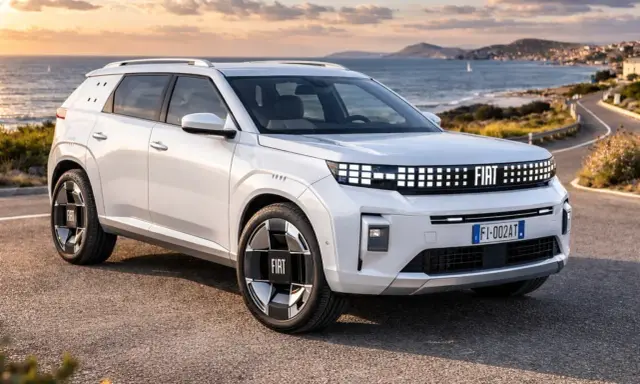 Un'imponente Fiat, quasi un giga panda, sfreccia su una strada costiera al tramonto.