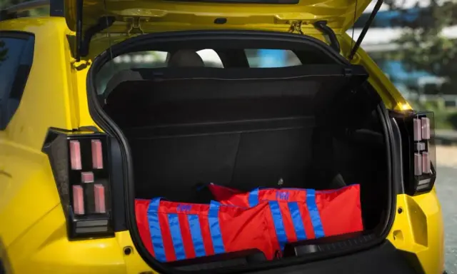 Bagagli rossi con strisce blu nel bagagliaio di una Fiat Panda, dimensioni generose per ogni avventura.