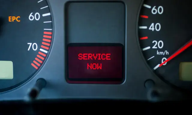 Car dashboard with EPC light on and "SERVICE NOW" message displayed in red.