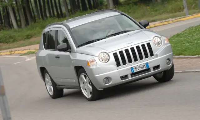 Jeep Compass in argento su strada sterrata, forse con qualche problema di trazione.