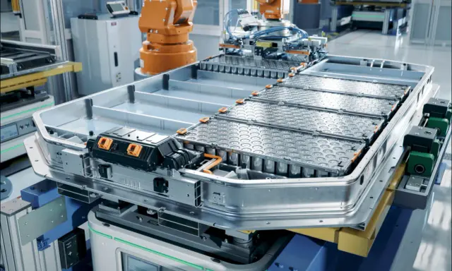 Assemblaggio di batterie del futuro in una fabbrica automatizzata. Un robot industriale lavora su un pacco batterie per veicoli elettrici.