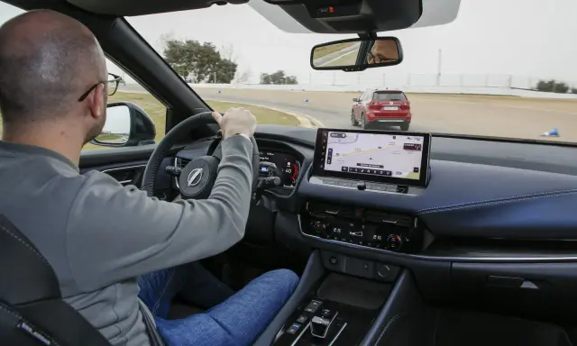 Uomo al volante su una pista, con un'altra auto rossa davanti. Il navigatore mostra il "Circuito del Jarama", ideale per chi vuole aumentare cavalli auto.