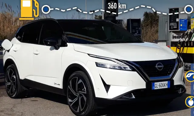 Nissan Qashqai e-POWER: potenza e autonomia per 360 km. L'auto è bianca, con tetto nero, e si trova vicino a una colonnina di ricarica.