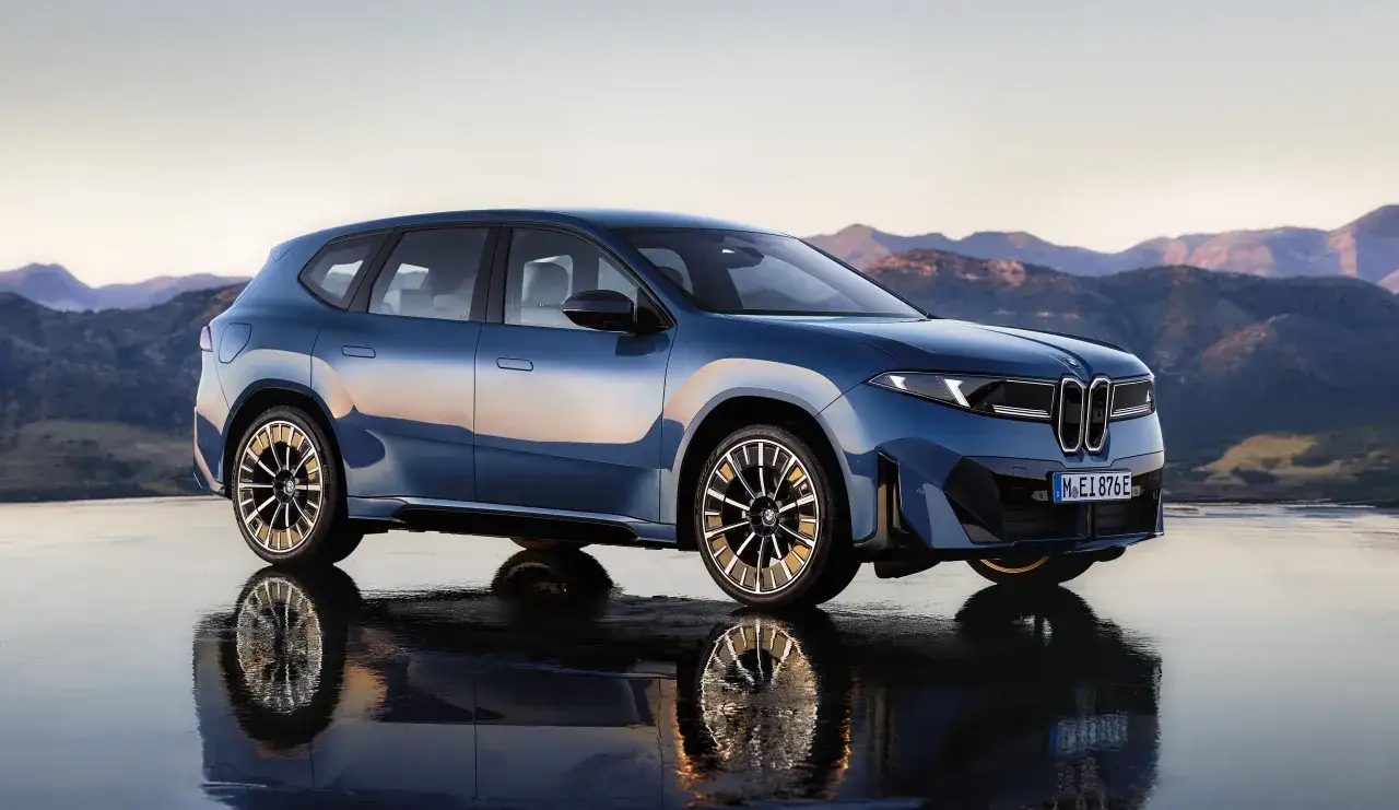 Blu SUV elettrica con riflesso sull'acqua, pronta per un viaggio di 400 km autonomia.