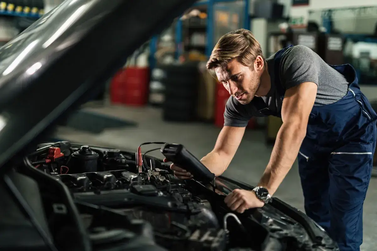 Meccanico controlla il motore diesel che non sale di giri, usando uno strumento diagnostico.