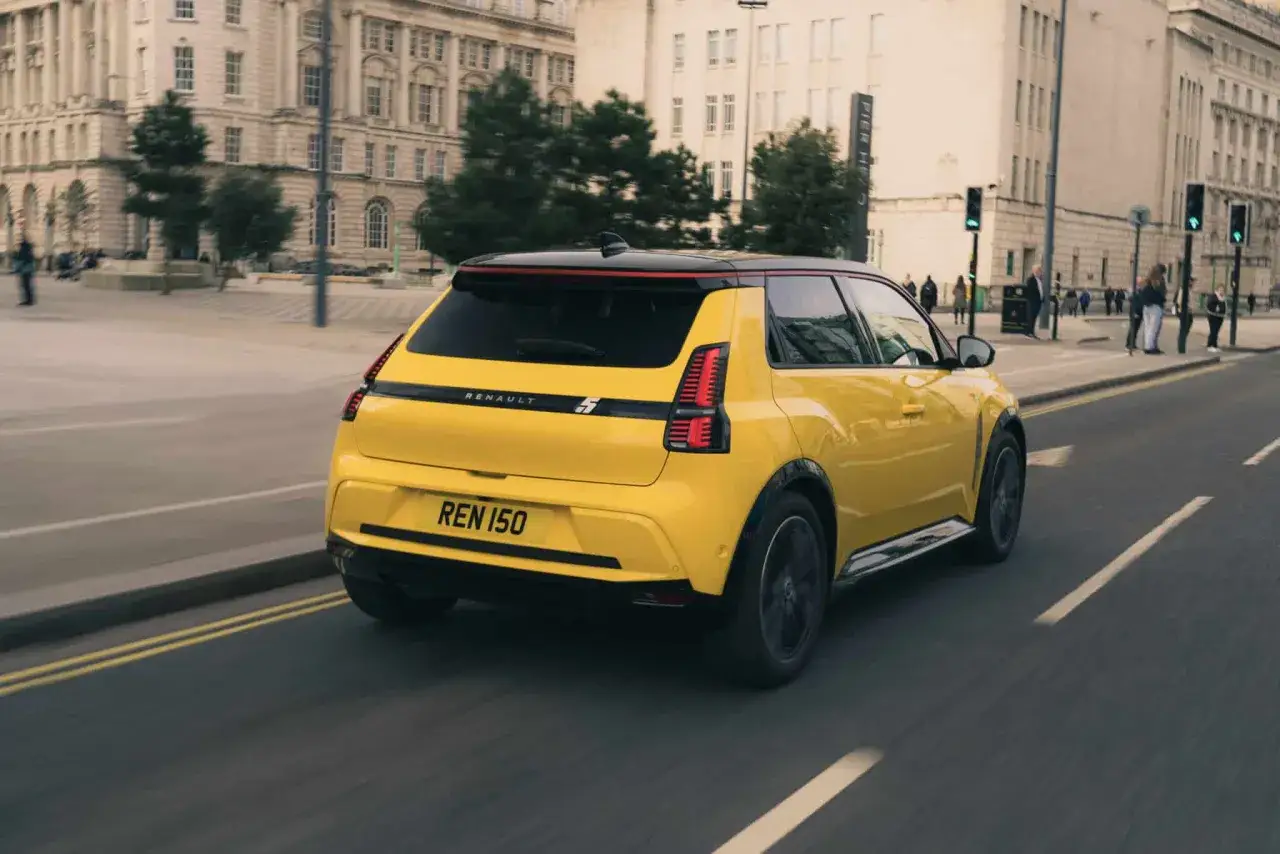 La Renault 5 elettrica sfreccia in città, dimostrando le sue prestazioni agili e moderne.
