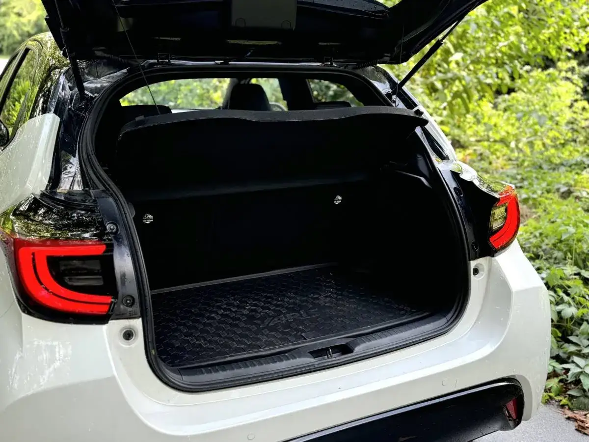 Bagagliaio aperto di una Toyota Yaris Hybrid. Dettagli sul vano e sul design posteriore, utili per la sua scheda tecnica.