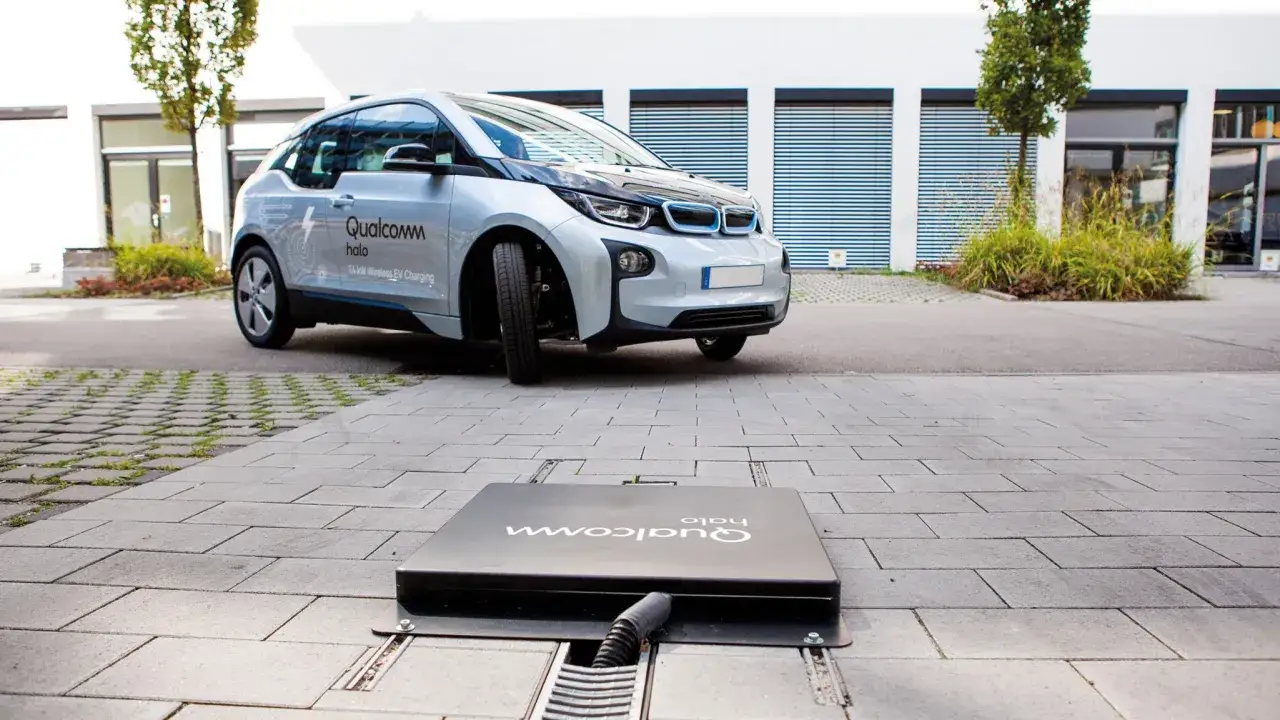 Un'auto elettrica si avvicina a una piastra per la ricarica wireless auto elettriche a terra.