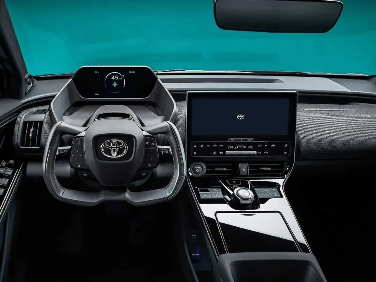 Interni moderni della Toyota bz4x: volante, cruscotto digitale e ampio display centrale.