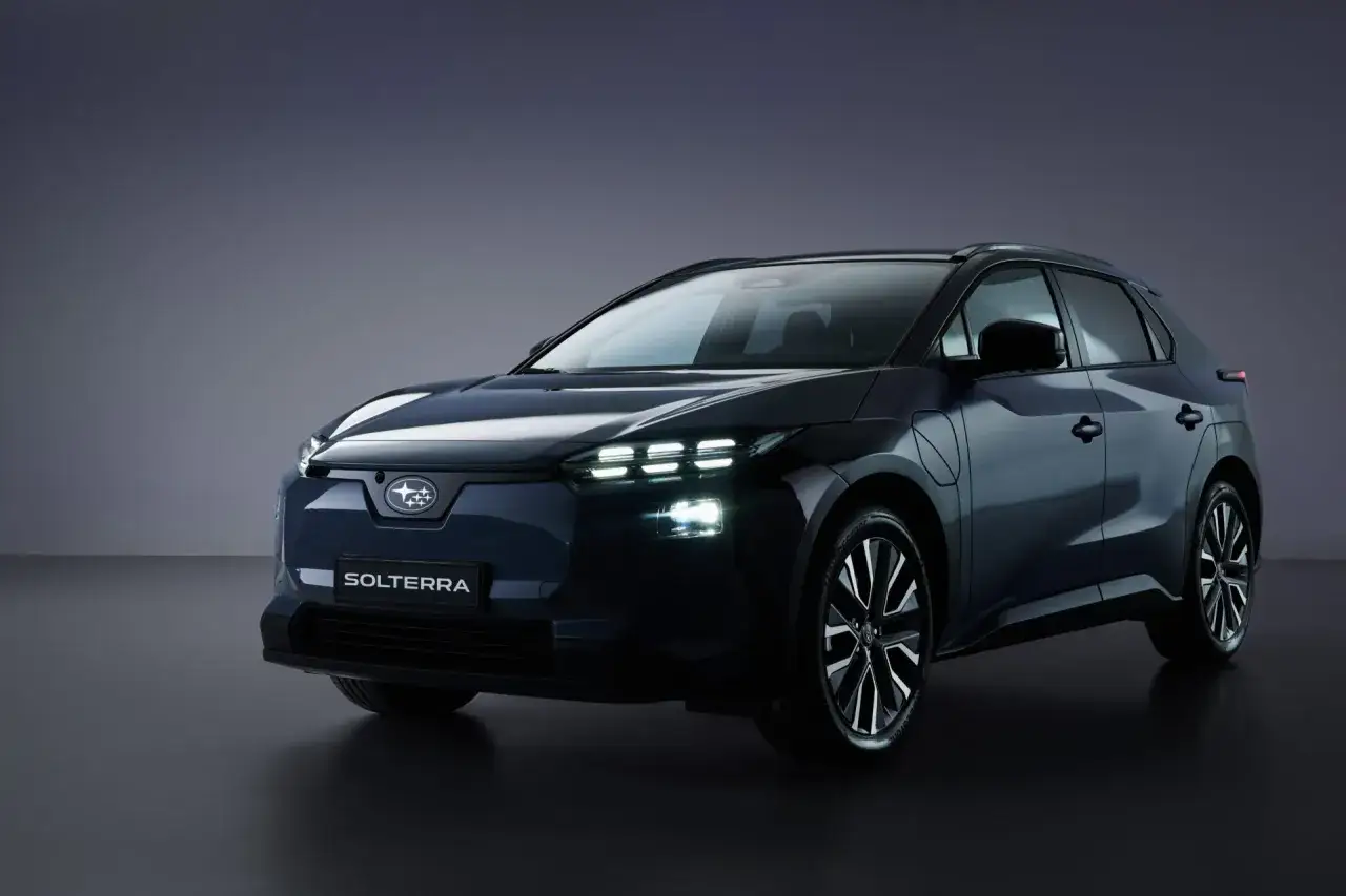 La nuova Subaru Solterra, un'elegante subaru elettrica, brilla con i suoi fari a LED su sfondo scuro.