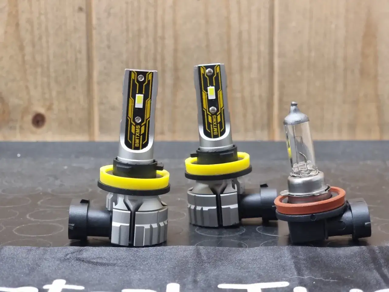 Due fendinebbia auto LED moderni accanto a una lampadina alogena tradizionale. Pronti per migliorare la visibilit&agrave;.