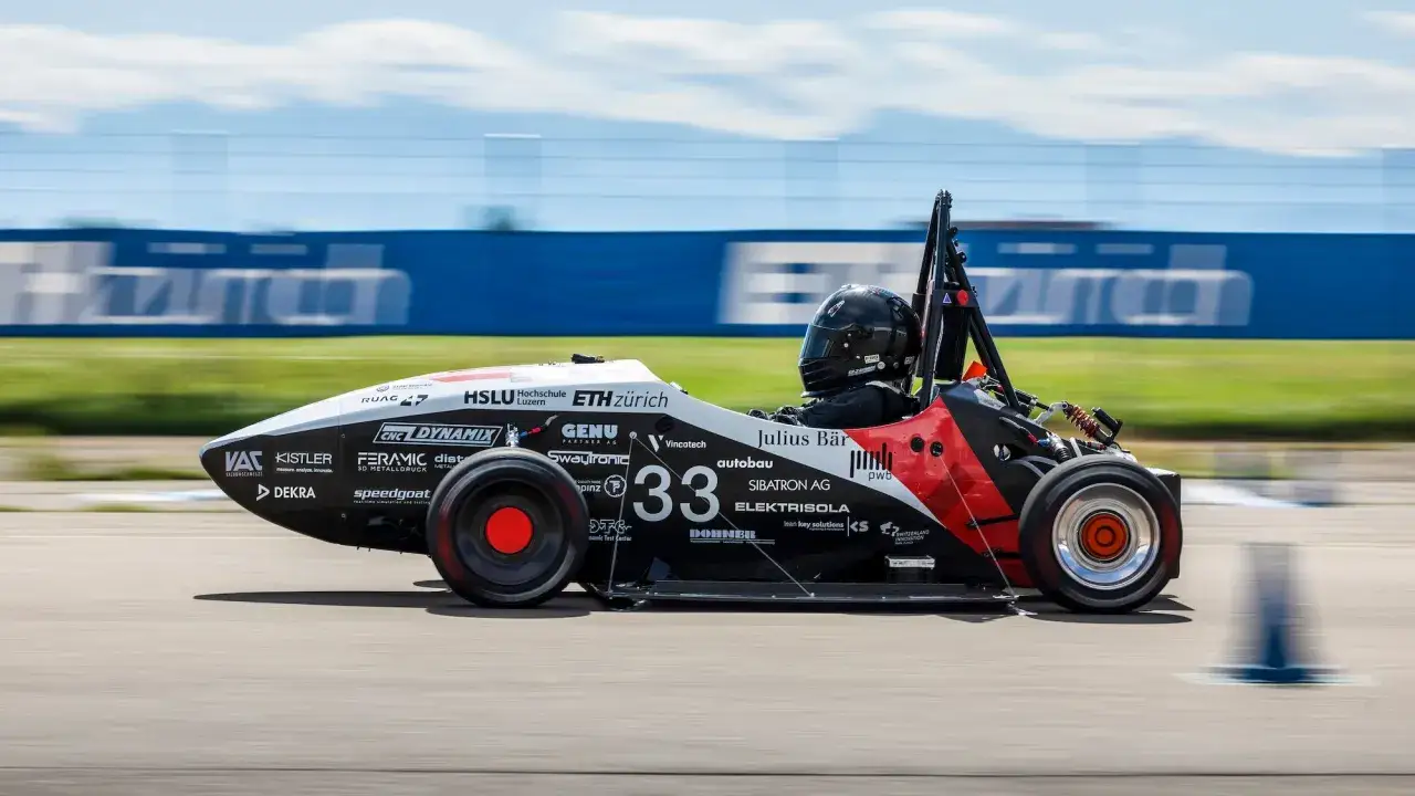 Auto elettrica da corsa numero 33 sfreccia in pista, dimostrando la sua velocità.