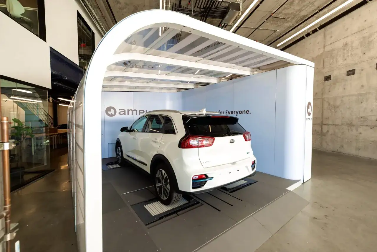 Stazione di battery swap per auto elettriche. Una Kia bianca &egrave; posizionata su una piattaforma per la sostituzione rapida della batteria.