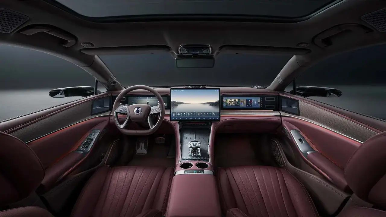Interni lussuosi della Denza Z9 GT: sedili in pelle bordeaux, ampio display centrale e illuminazione d'ambiente.
