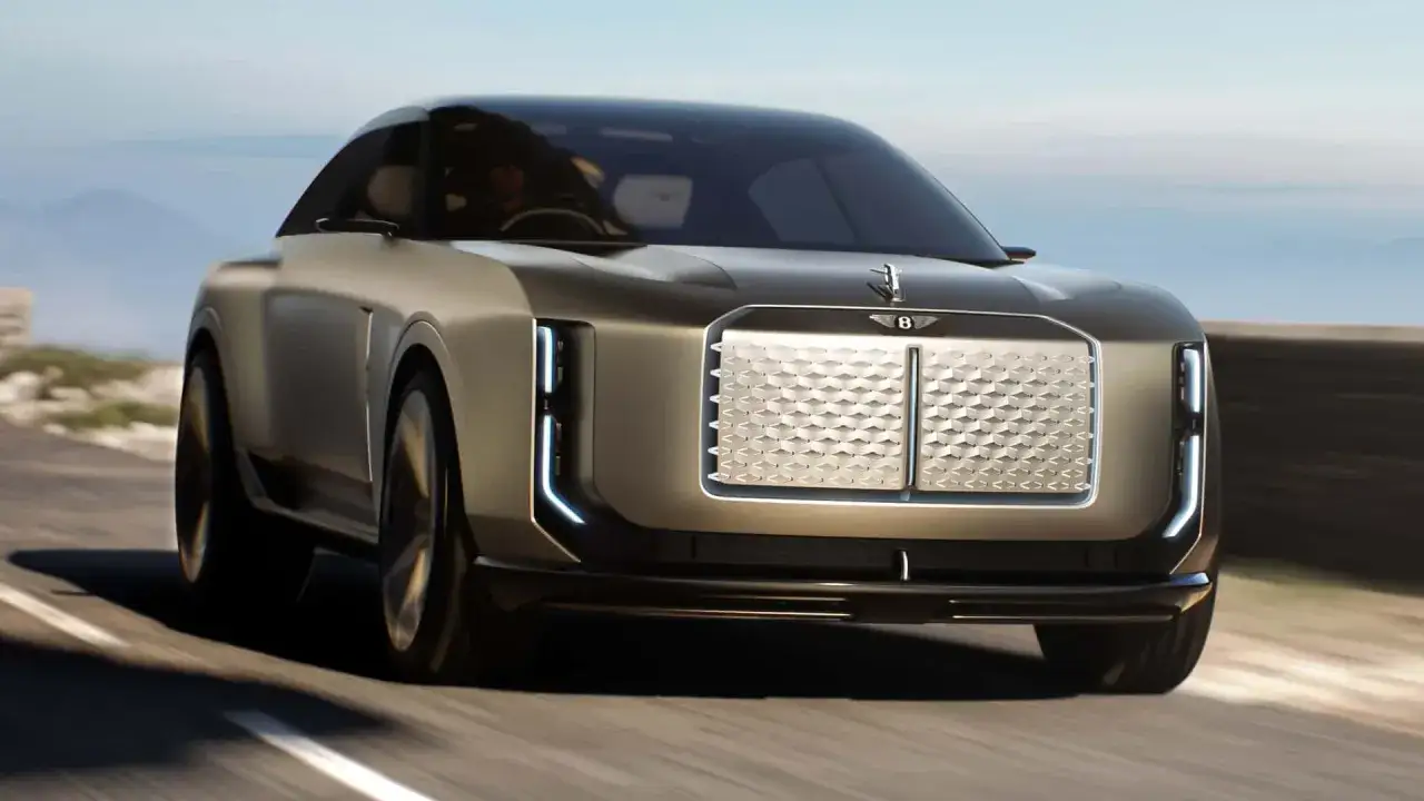 La Bentley elettrica avanza su una strada panoramica, con il suo design futuristico e la griglia iconica.
