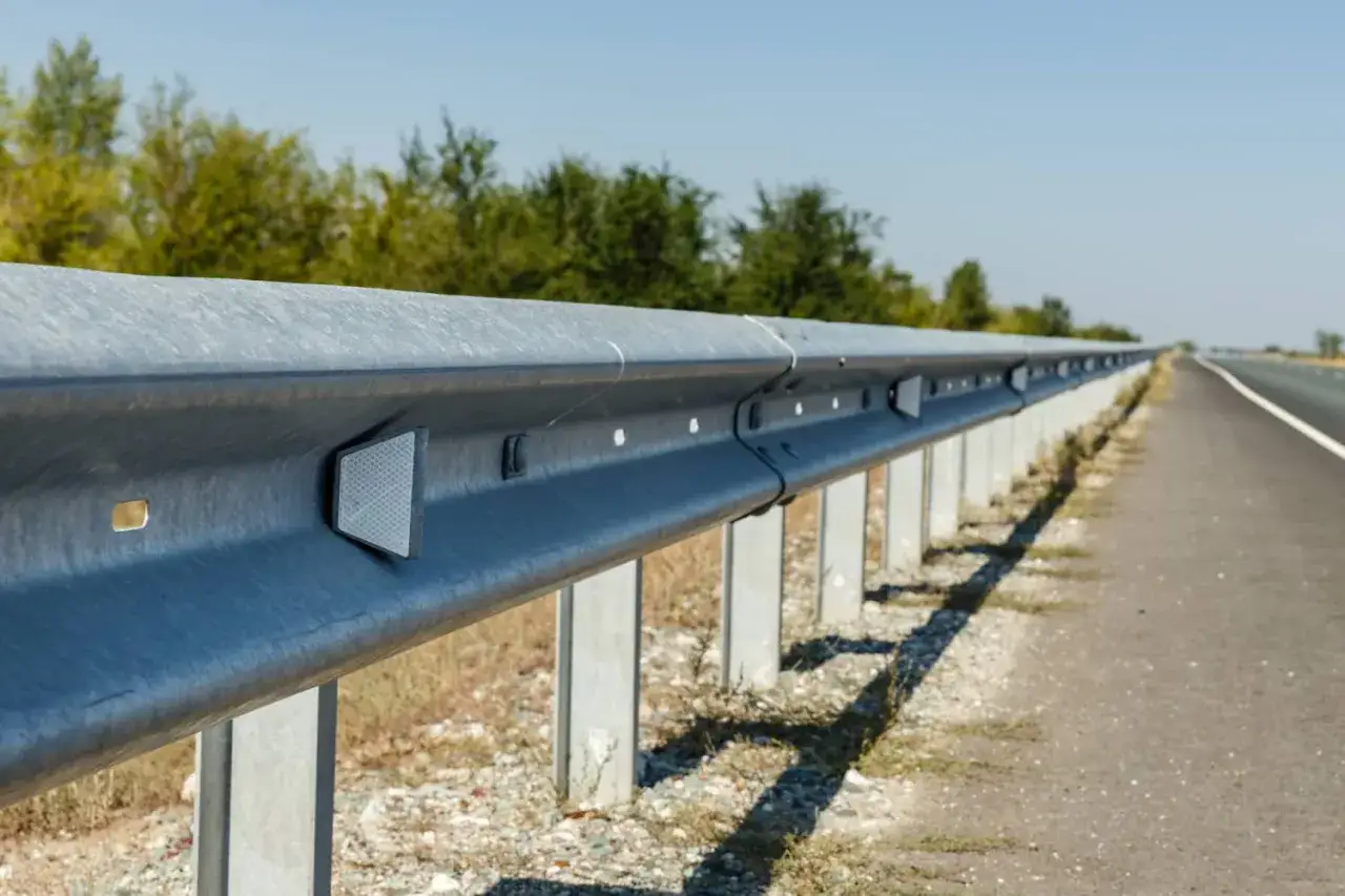 Guardrail autostradale con catadiottri, dispositivi riflettenti che migliorano la visibilità notturna e in condizioni di scarsa illuminazione.