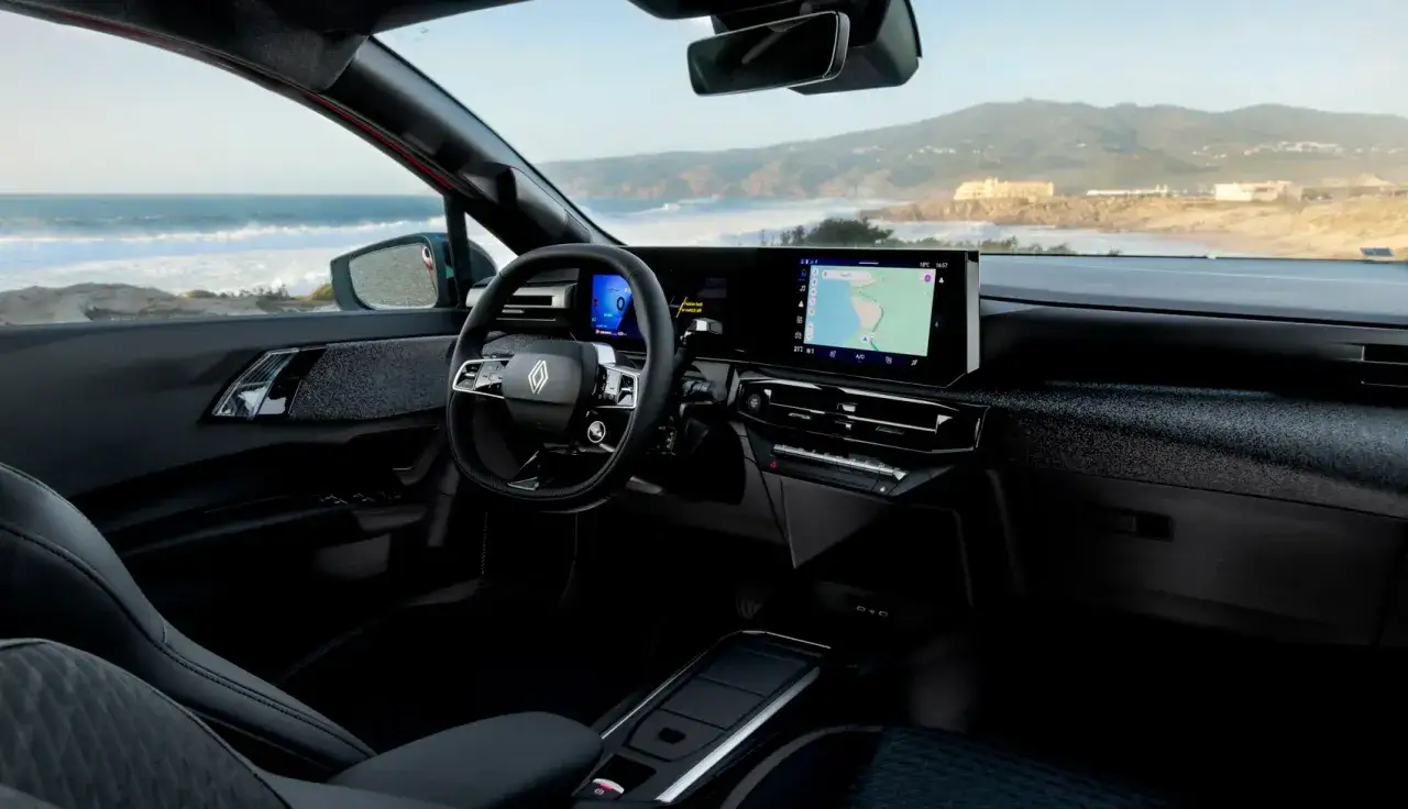 Interni moderni della nuova Clio 2026: volante, ampio display con navigatore e vista mare.