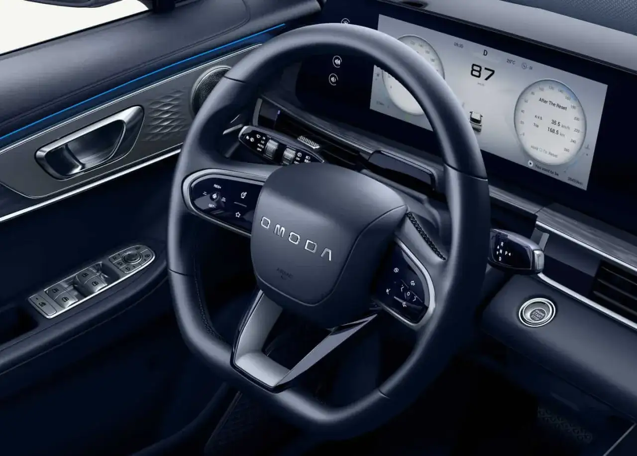 Interno moderno dell'Omoda 4 con volante e cruscotto digitale.
