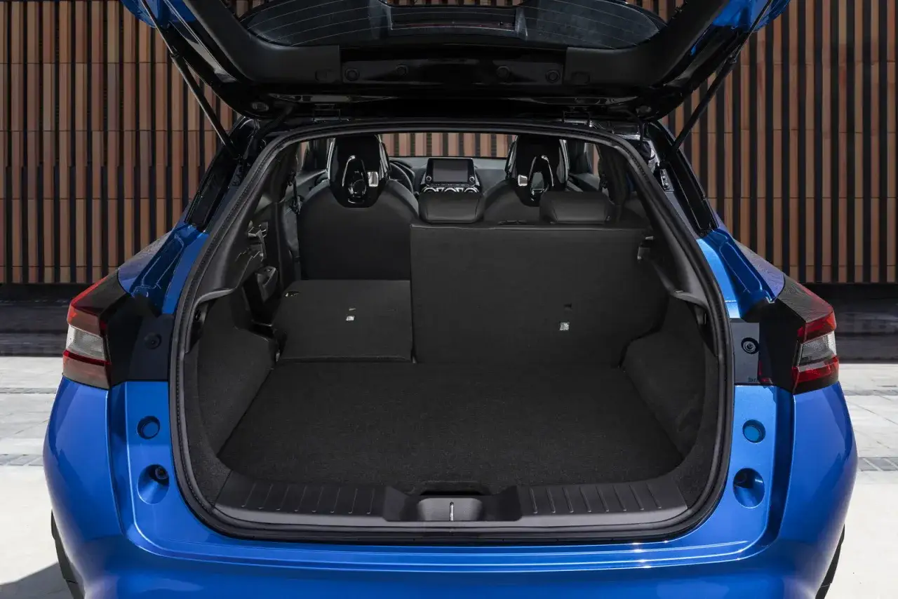 Bagagliaio del Nissan Juke 2026 blu, con sedili posteriori abbassati per massimizzare lo spazio.