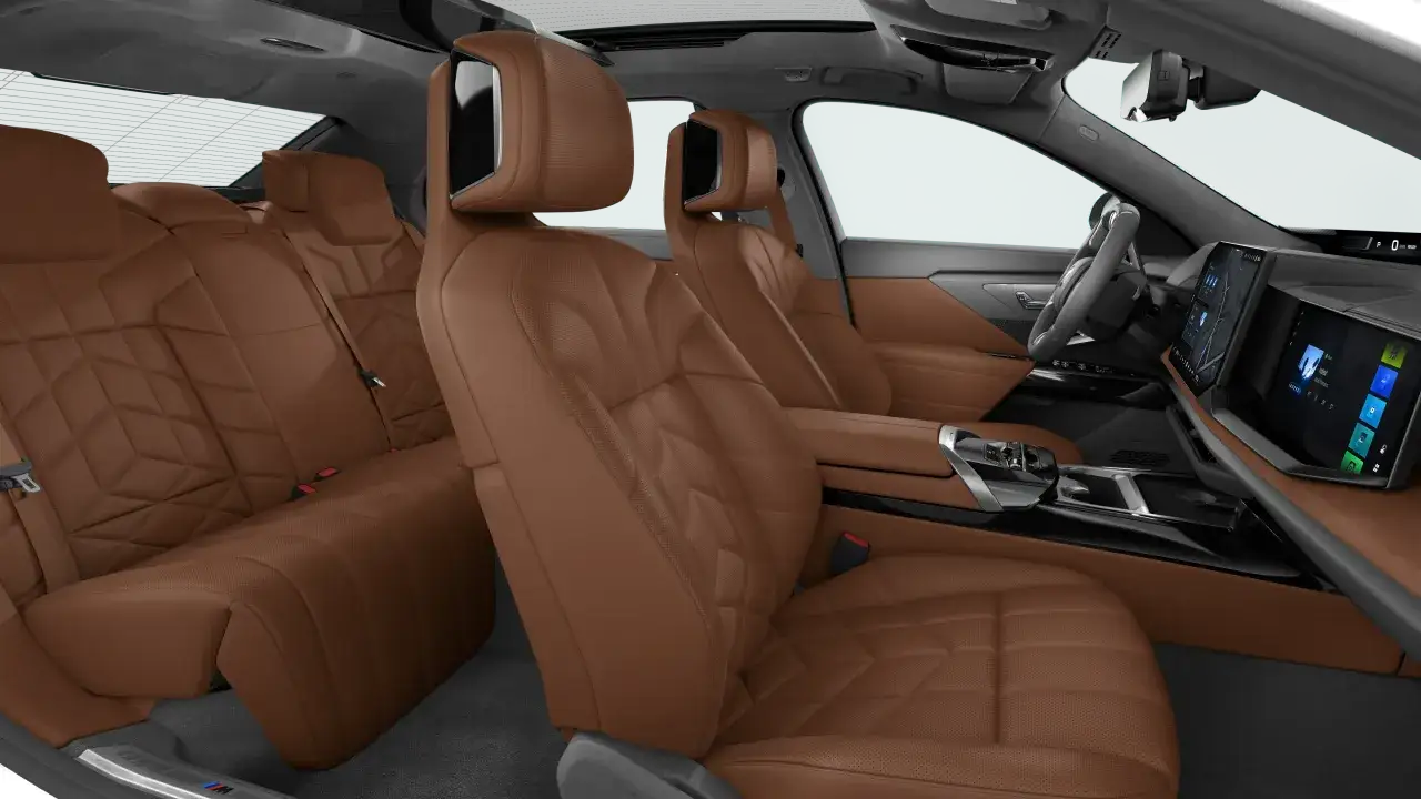Interni lussuosi della BMW i7 con sedili in pelle color caramello trapuntati e schermi digitali.