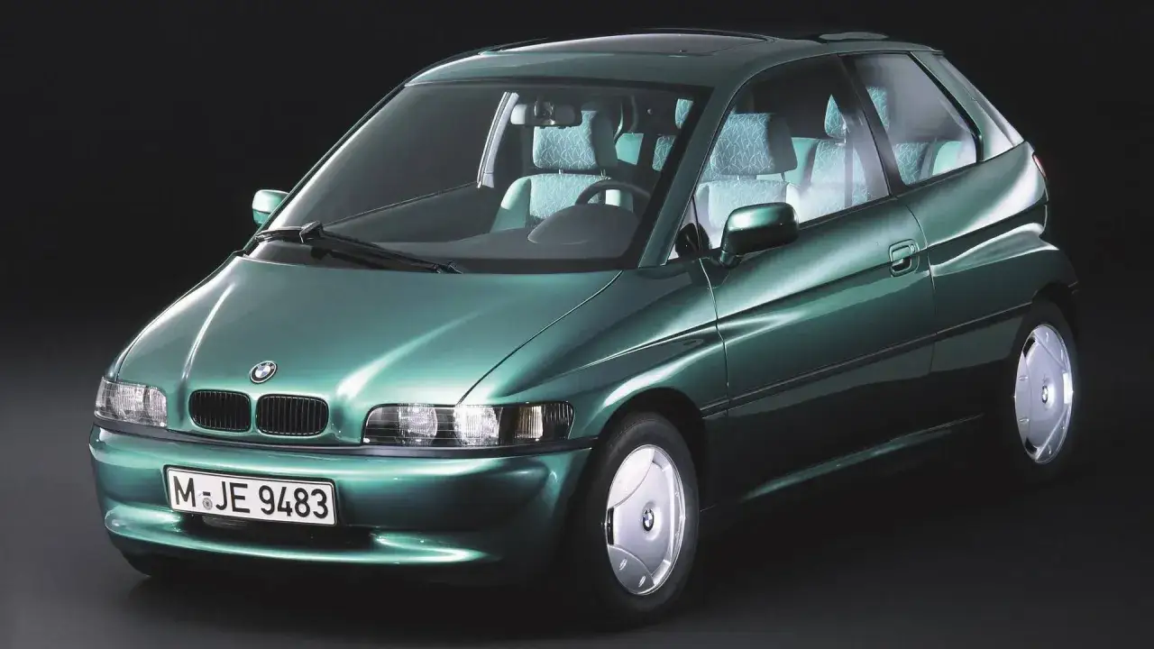 La BMW E1, un prototipo elettrico verde metallizzato, mostra interni chiari e un design futuristico.
