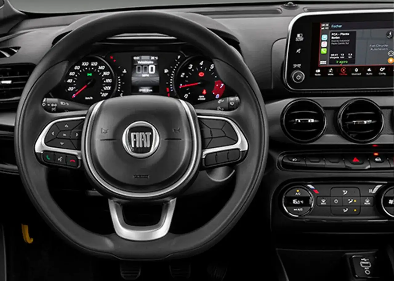 Interno della Fiat Argo: volante multifunzione con logo Fiat, cruscotto digitale e schermo touchscreen.
