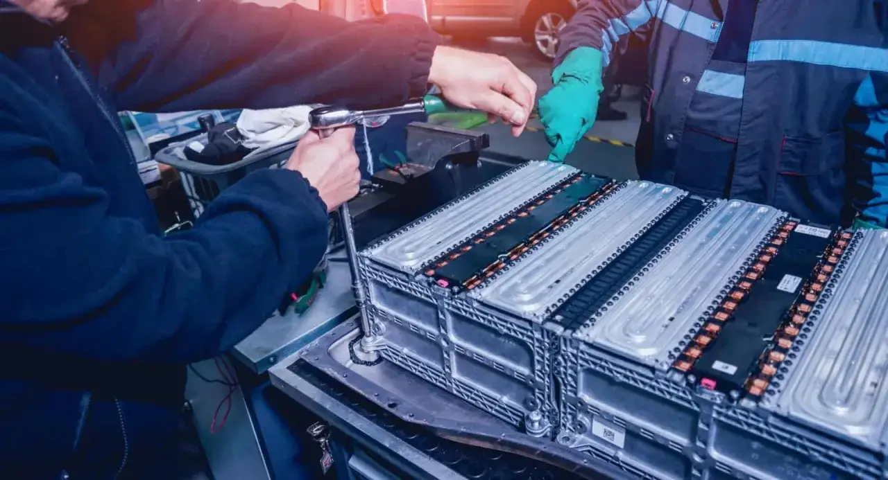 Tecnici lavorano su un pacco batterie auto elettrica. Il costo batteria auto è un fattore importante per la transizione ecologica.