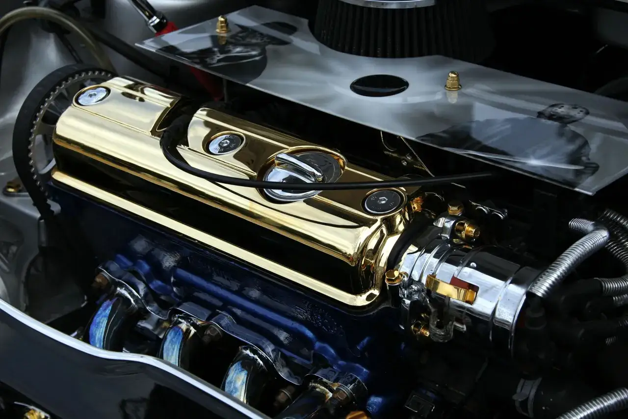Motore lucido con coprivalvole dorato e collettori cromati, pronto per aumentare cavalli auto.