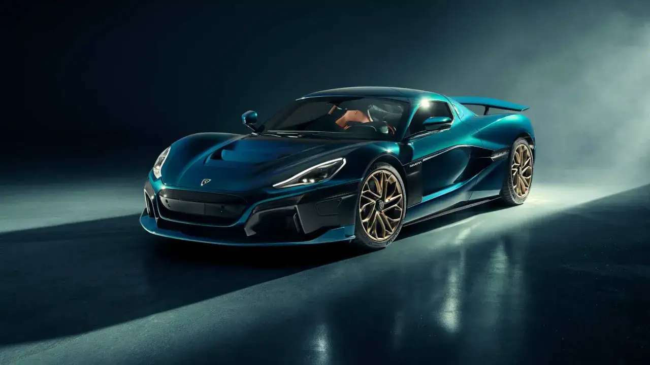 La Rimac Nevera, un'hypercar elettrica blu petrolio con cerchi dorati, brilla sotto i riflettori, pronta a scatenare la sua potenza.