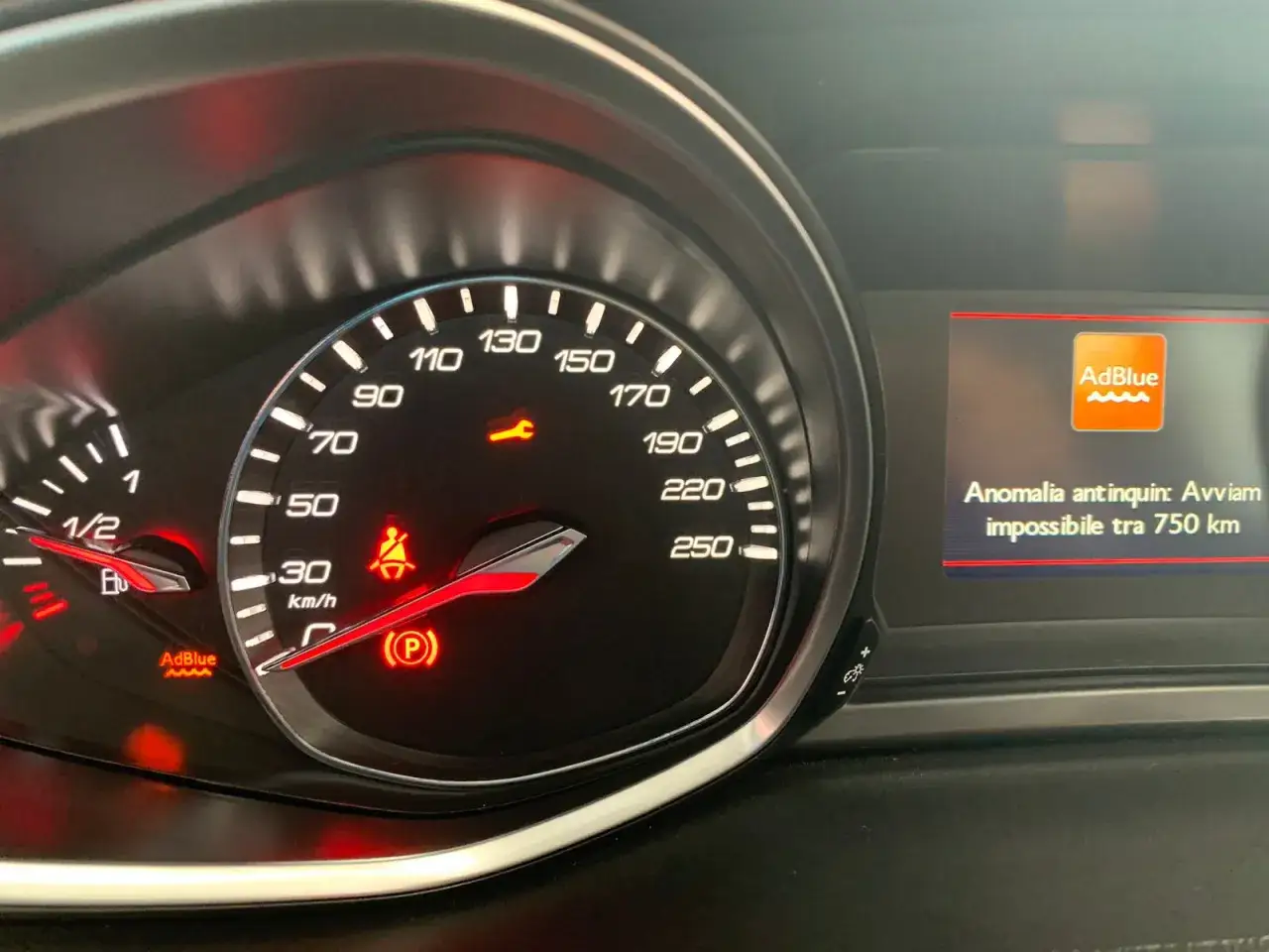 Cruscotto auto con spia AdBlue accesa e messaggio