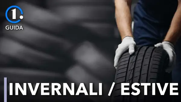 Guida: cambio gomme invernali in estate. Mani guantate tengono un pneumatico.