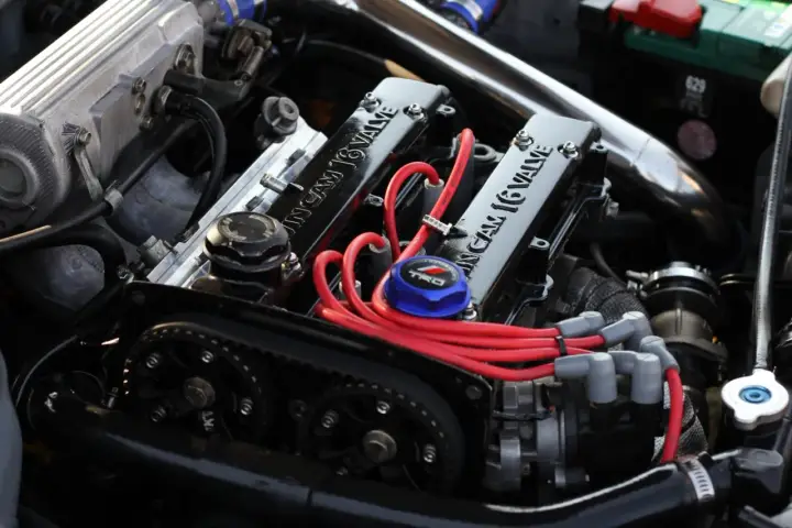 Motore elaborato con coperchio valvole "16 VALVE", candele rosse e pulegge. Un aggiornamento centralina auto potrebbe ottimizzare queste prestazioni.