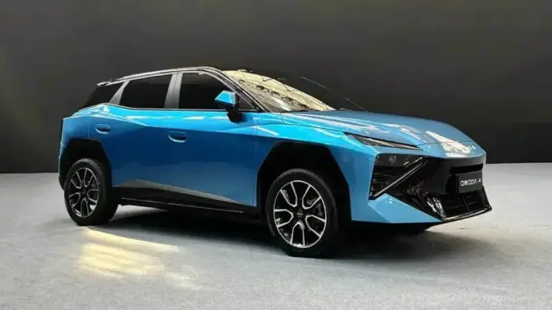 Un'elegante Omoda 4 blu metallizzato, con un design futuristico e cerchi in lega sportivi, si presenta su un pavimento grigio.